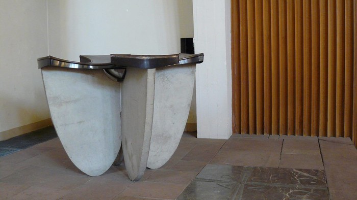 Ein modernes, weißes Sideboard steht an einer beigen Wand mit vertikalen Holzleisten.