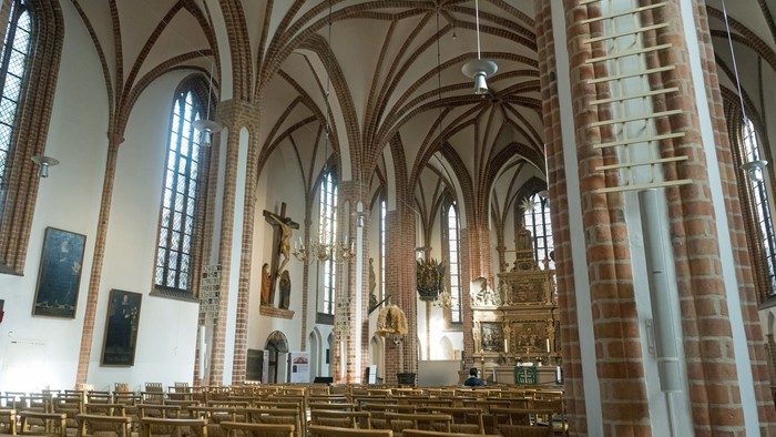 Großzügige Kircheninneraum mit hohen Bögen und Buntglasfenstern
