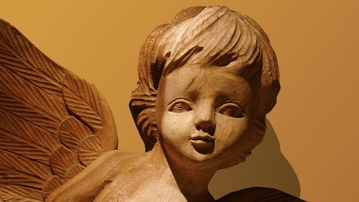 Engelgestalt mit Flügeln, sanfter Gesichtsausdruck, warmer Hintergrund.