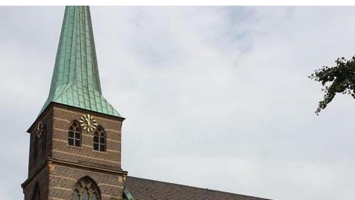 Foto der Cyriakuskirche Bottrop - im Vordergrund eine weiße Taube