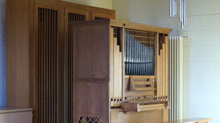 Ein hölzernes Musikinstrument mit Tasten und Pfeifen in einem Raum