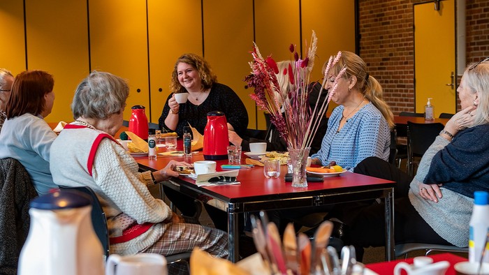 En gruppe kvinder sidder ved et bord og spiser morgenmad i et restaurant.