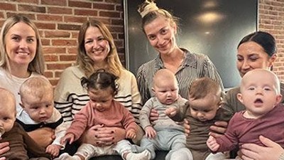 En gruppe kvinder sidder sammen med deres spædbarn i en hyggelig indretning.