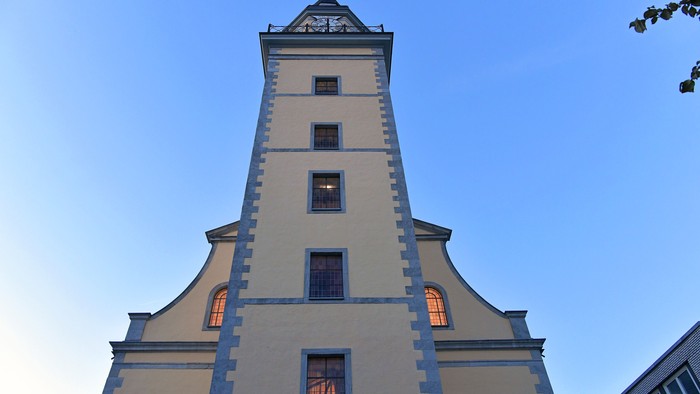 Das Bild zeigt einen hohen, weißen Turm mit blauen Akzenten und mehreren Fenstern.