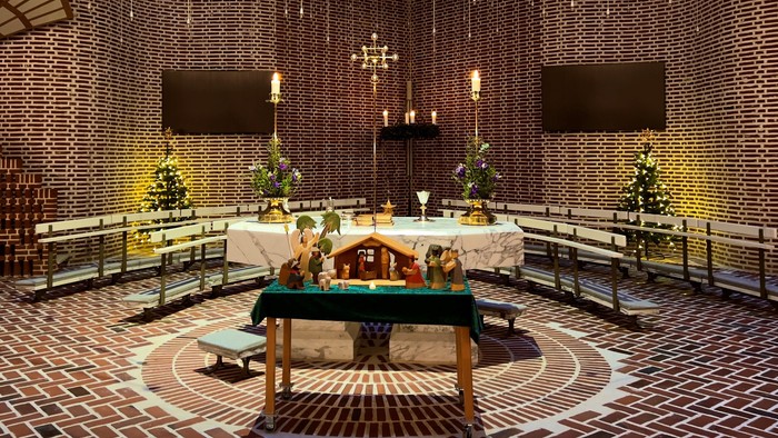 Kirkeinteriør med prydet alter, lysekroner og flisebelagte vægge.