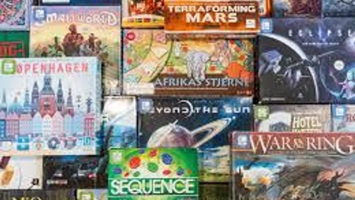 Billedet viser en samling af brætspil med forskellige temaer og design.