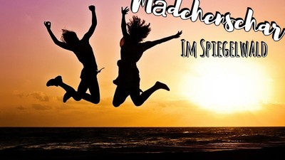 Zwei Personen springen freudig am Strand bei Sonnenuntergang