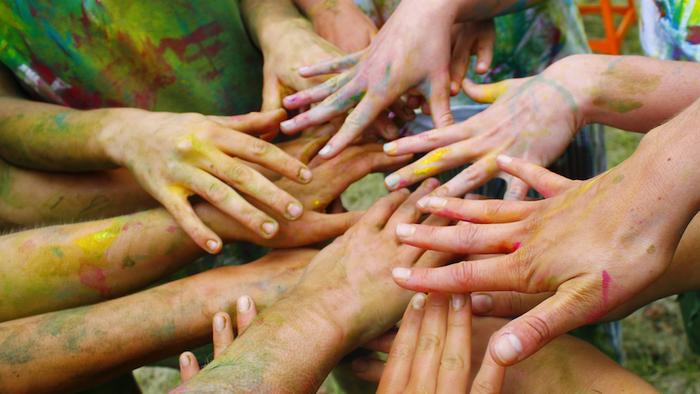 Mehrere Hände mit bunten Farben
