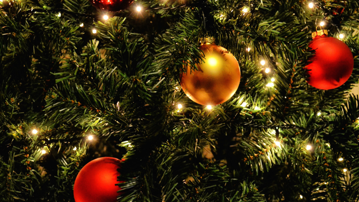 En juletree med lys og glitrende pynt