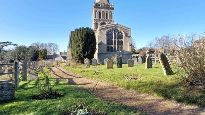 Church with tall steeple and graveyard in foreground