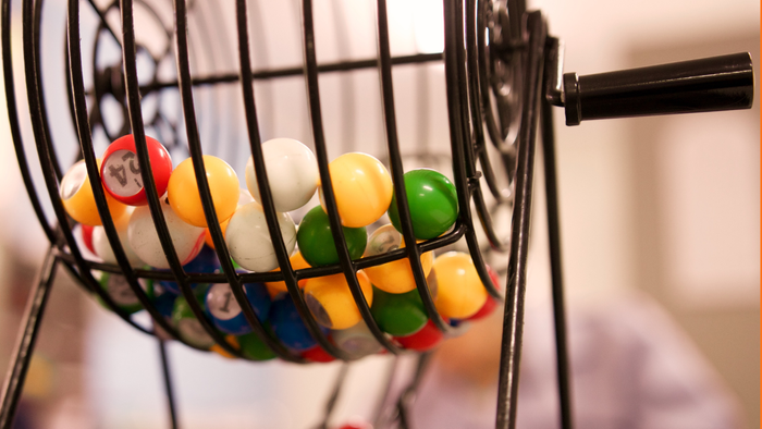 Oben Bingokugeln in einer Drehvorrichtung. Unten steht Bingo - mach mit!