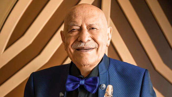 Älterer Mann im blauen Anzug mit Klarinette.