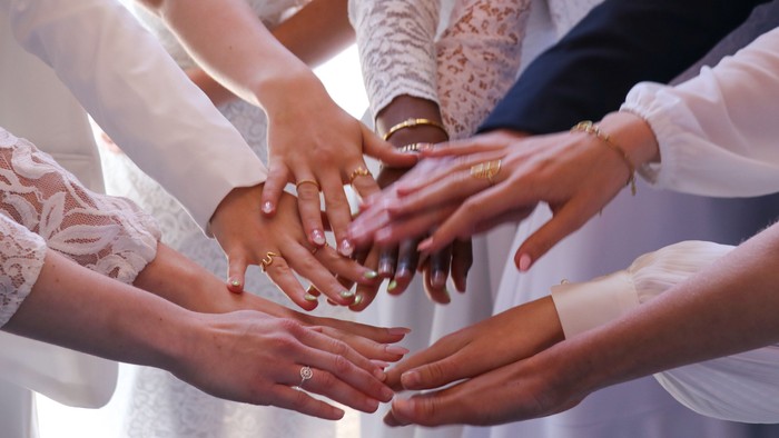 En gruppe af hender, der holder hinanden sammen, symboliserer enhed og samarbejde