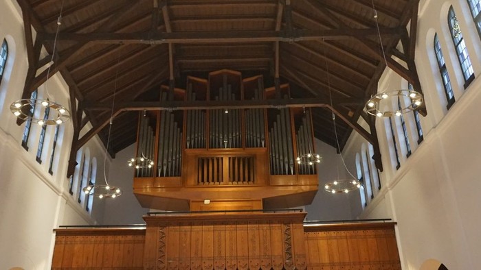 Die Kirche mit hohem Holzorgan und hohen Fenstern
