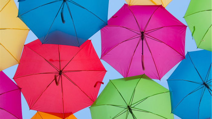 Bunte Regenschirme in verschiedenen Farben am Himmel
