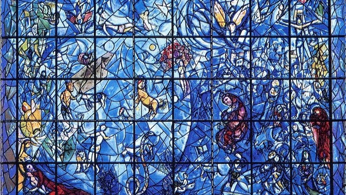 Das Bild zeigt ein farbenfrohes Glasfenster mit abstrakten und figurativen Elementen.