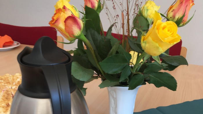 Blumenstrauß in Vase auf Tisch mit Kaffeekanne