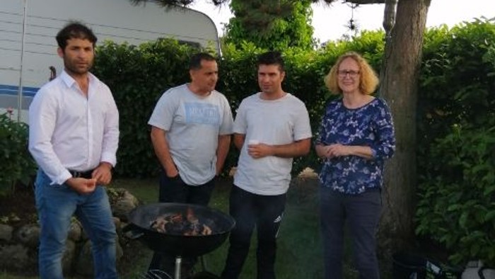 Firefyr i haven med fire personer og en grill
