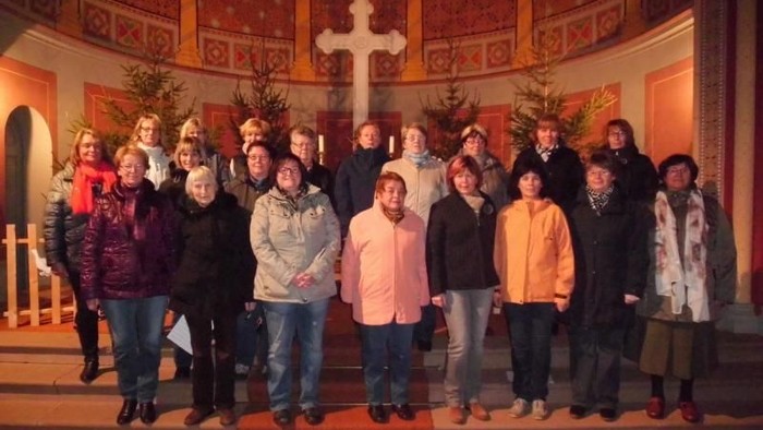 Eine Gruppe von Menschen posiert in einer Kirche vor einem Altar.