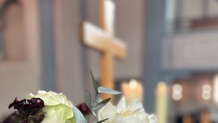 Blumenstrauß vor Kreuz in Kirche