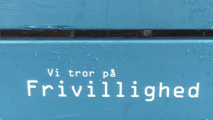 Blå dør med skrift 'Vi tror på Frivillighed'