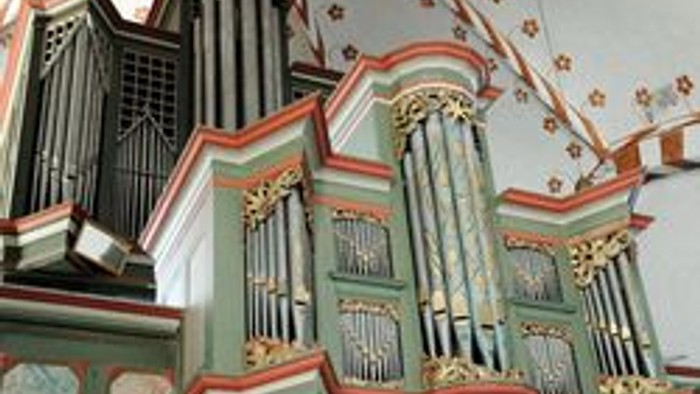 Ein prächtiger Kirchenorgel mit verzierten Pfeifen und farbenfrohen Dekorationen.