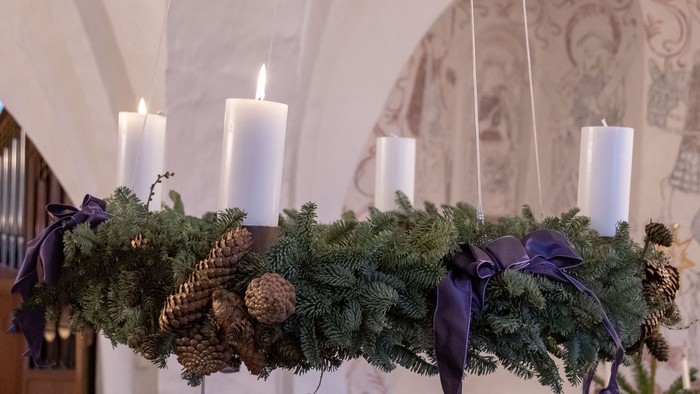 En hængende julekrans med lysende lygter og nødder i en indendørs lokalitet