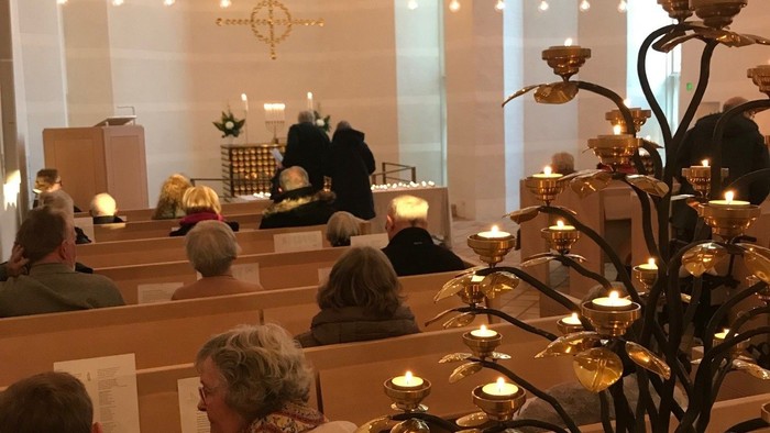 En kirke med folk, lys og lysestake