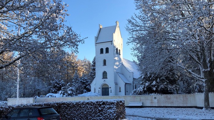 En snødekt kirke med en bil foran