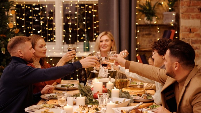 Freundliche Gruppe feiert Weihnachten mit Essen und Getränken