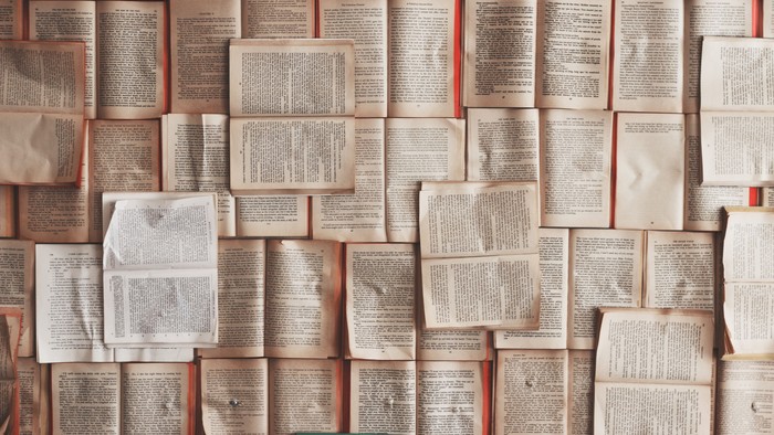 Ein Haufen alter, aufgeschlagener Bücher mit vergilbten Seiten.