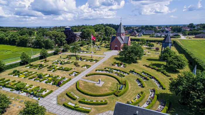 En smuk have med rounder og en røde bygning i midten