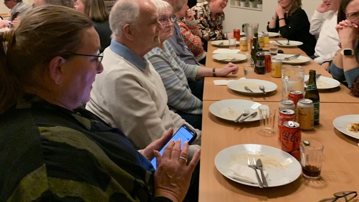 En gruppe mennesker spiser sammen i et restaurant.