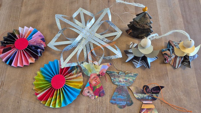 Billedet viser forskellige papirkunsthåndværksudforminger på en bord.