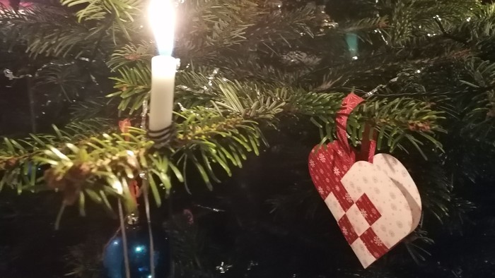 En juletree med lysende lys, pynt med hjerter og stjerner