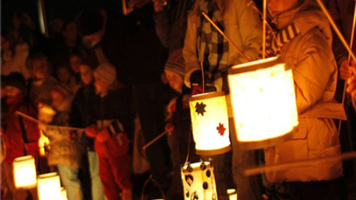 Mennesker, der holder med lygter i et mørkt miljø.