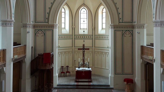 Großzügige Kirche mit hohen Bögen und Stufen zum Altar.