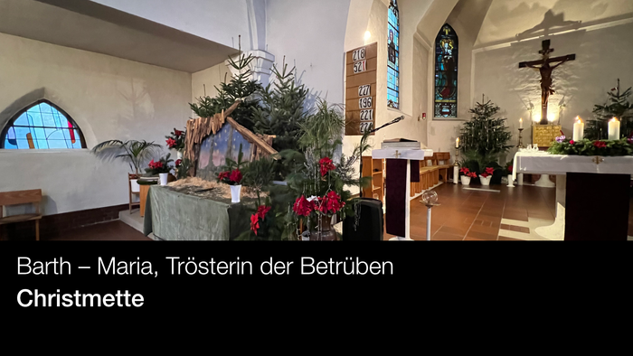 Innenraum einer Kirche mit Weihnachtsdekoration und Kreuz