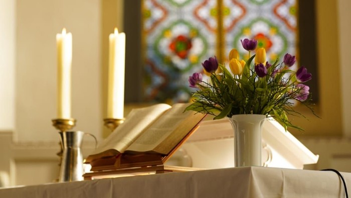 Altartisch mit Blumen, Bibel und Kerzen