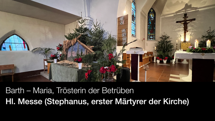 Innenraum einer Kirche mit Weihnachtsdekoration und Kreuzigungsgruppe