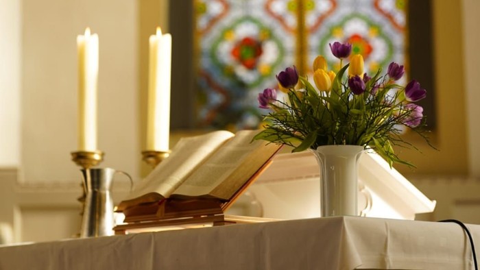 Altartisch mit Blumen, Bibel und Kerzen