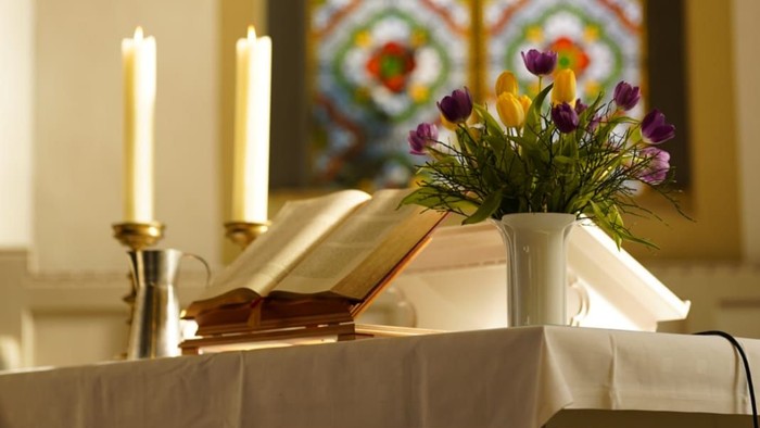 Altartisch mit Blumen, Bibel und Kerzen