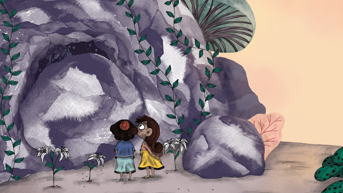 To børn står nær store sten med grønne planter.