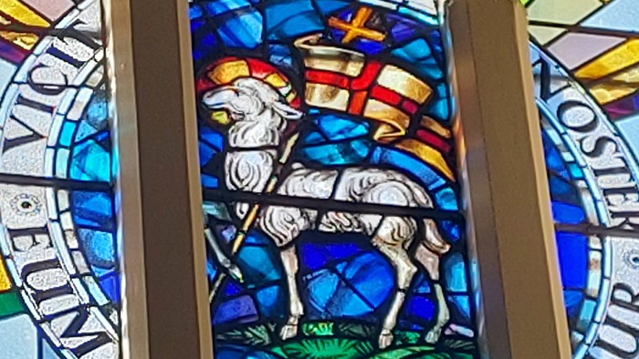 Buntes Kirchenfenster mit Lamm und Kreuz