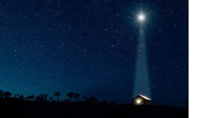 Et klart lys skinner opad mod en stjerneklar nattehimmel.