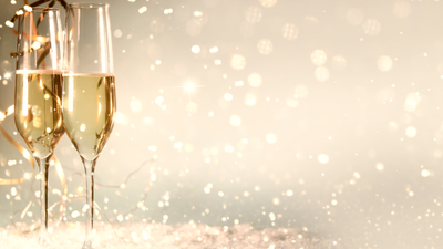 To champagneglas på en festlig baggrund med glitrende lysepartikler