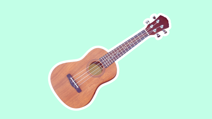 Ein braunes Ukulele auf hellgrünem Hintergrund