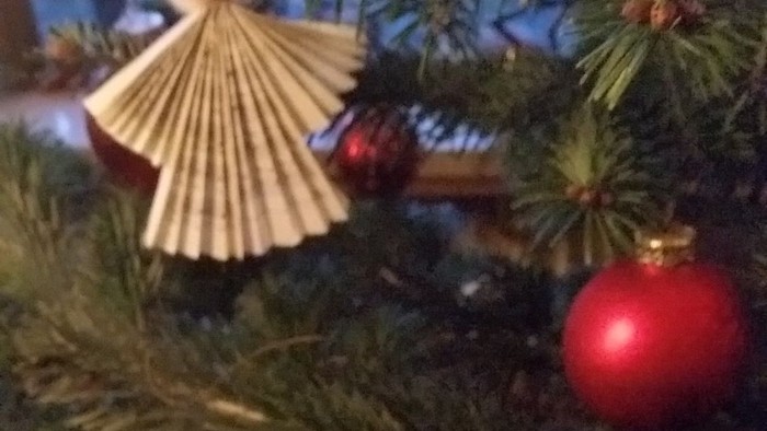 Weihnachtsbaum mit gelbem Sternschmuck und rotem Christbaumkugel.