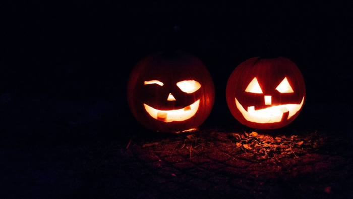To halloweenly udskårne pumpker på en mørk baggrund