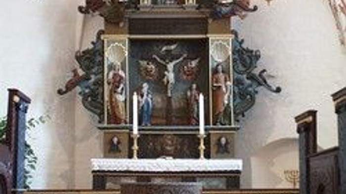 Alter i kirke med kalkmalerier og lysstake